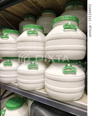 Large white plastic barrels with green lids and green handles on a shelves in a supermarket Large white plastic barrels with green lids and green handles on a shelves in a supermarket 141188052