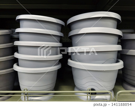Gray plant pots arranged neatly on shelves with a variety of sizes for floral displays and plant arrangements Gray plant pots arranged neatly on shelves with a variety of sizes for floral displays and plant arrangements 141188054