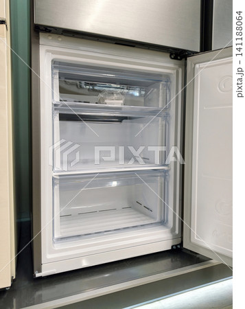 Large gray refrigerator bottom freezer with open door, perfect for storing frozen foods, now available at a hypermarket 141188064