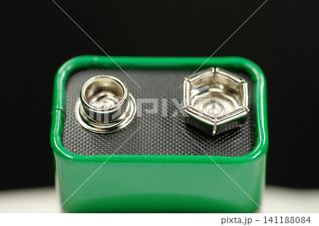 Green 9V battery simple composition, electric battery with connectors delivering nominal 9 volts and ready for powering electronic devices Green 9V battery simple composition, electric battery with connectors delivering nominal 9 volts and ready for powering electronic devices 141188084