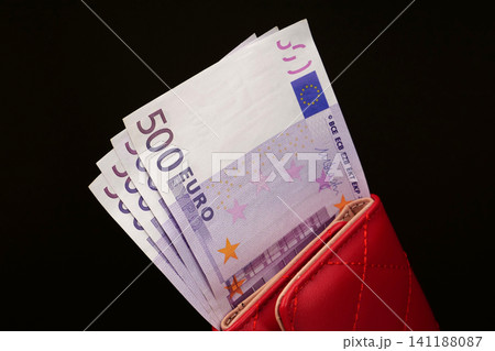 Four 500 Euro banknotes, amounting to 2000 Euros, inside a red wallet, illustrating the power of European Union currency 141188087