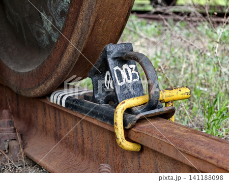 Industrial train wheel stopped safely with metal brake block on commercial railroad track Industrial train wheel stopped safely with metal brake block on commercial railroad track 141188098