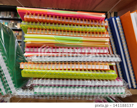 Assortment of spiral softcover notebooks arranged neatly in shop Assortment of spiral softcover notebooks arranged neatly in shop 141188137