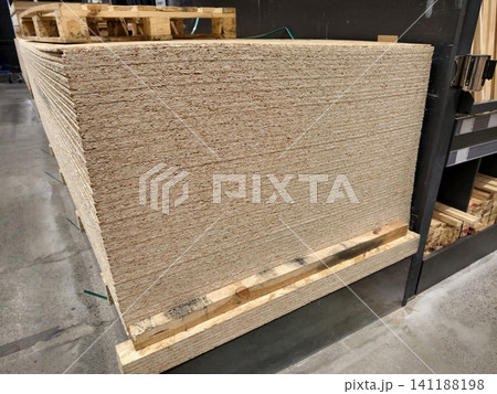 Oriented Strand Board or OSB, structural wood board for wall construction and other wood product manufacturing kept in industrial warehouse Oriented Strand Board or OSB, structural wood board for wall construction and other wood product manufacturing kept in industrial warehouse 141188198