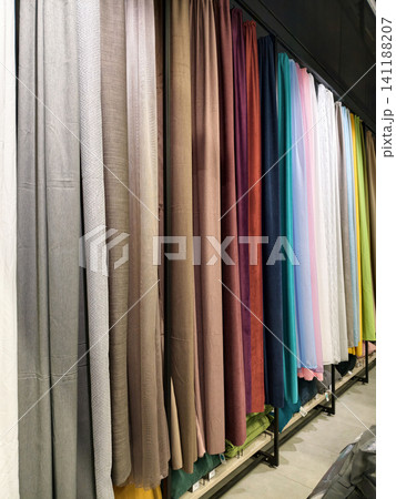 Colorful drapes in a store, showcasing multiple fabric options for windows Colorful drapes in a store, showcasing multiple fabric options for windows 141188207