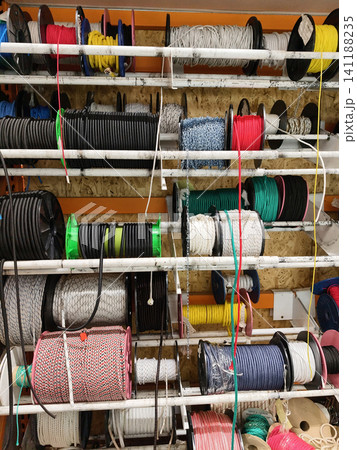 Heavy duty ropes cables and chains arranged in neat coils and reels on shelves in a hardware store supplying durable equipment for construction use Heavy duty ropes cables and chains arranged in neat coils and reels on shelves in a hardware store supplying durable equipment for construction use 141188235