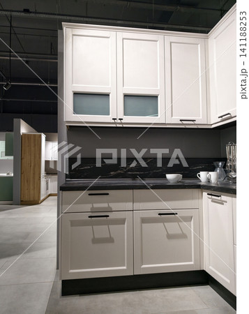 Sample kitchens set up for display in a large showroom to attract customer interest Sample kitchens set up for display in a large showroom to attract customer interest 141188253