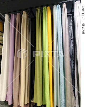 Multicolored curtains in a variety of shades arranged neatly inside a shop Multicolored curtains in a variety of shades arranged neatly inside a shop 141188255