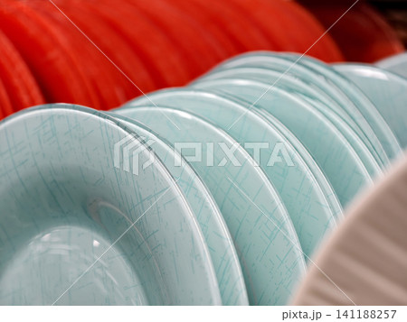 Beautiful light blue glass plates on shelves in supermarket, close up of tableware for kitchen and household use 141188257