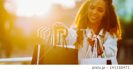 Young woman with shopping bags walking on street. , Sale concept. 141188471