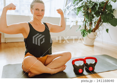 middle-aged woman doing Pilates at home 141188640