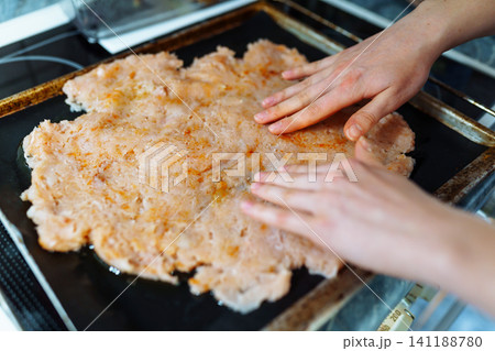 Women's hands prepare a minced meat dish Women's hands prepare a minced meat dish 141188780