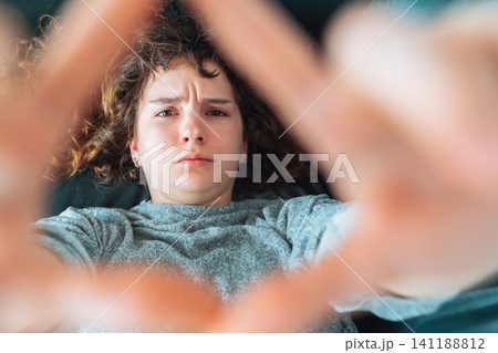 young red-haired woman relaxing on leather sofa 141188812