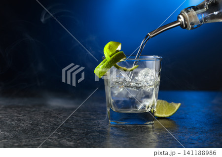 Vodka with lime and ice cubes in a fogged up glass. 141188986