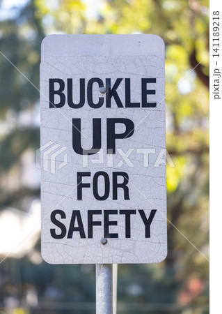 A buckle up for safety sign post located near a road in Western Sydney 141189218