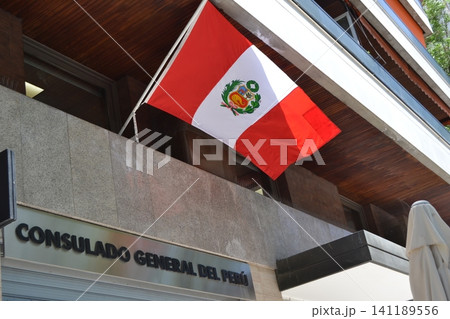 Peruvian national flag on consulate building facade waving above entrance for banner and background use in government and patriotic design applications Peruvian national flag on consulate building facade waving above entrance for banner and background use in government and patriotic design applications 141189556