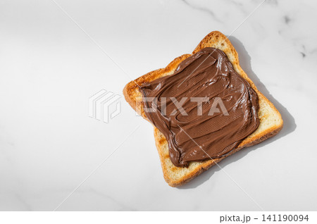 Toasted bread with chocolate cream on a marble background close up. 141190094