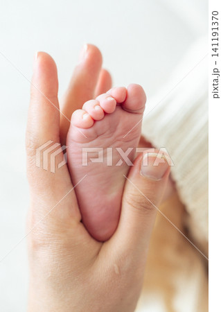 Minimal soft background with infant foot. Space for text. Concept of safety, care, motherhood and protection Minimal soft background with infant foot. Space for text. Concept of safety, care, motherhood and protection 141191370