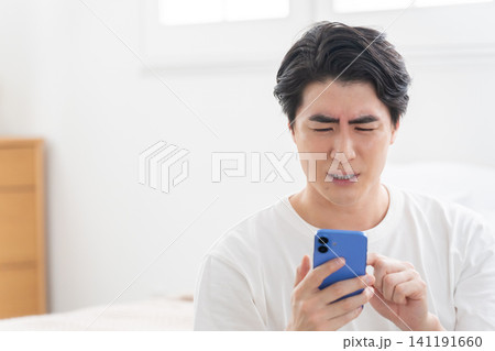 スマホを見る男性 スマホを見る男性 141191660