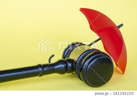 Judge gavel and red umbrella representing security and insurance with customizable space for text. Judge gavel and red umbrella representing security and insurance with customizable space for text. 141192220