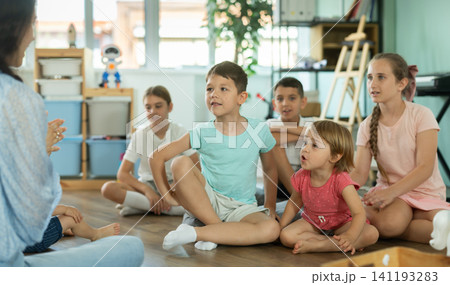 Little boys and girls enjoying storytime with educator at development-center 141193283