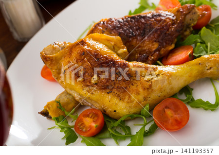 Fried chicken legs with arugula and tomatoes Fried chicken legs with arugula and tomatoes 141193357