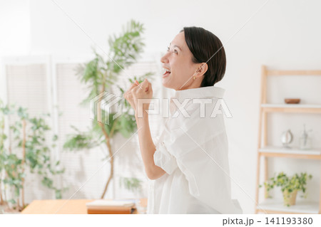リビングで喜ぶ30代女性 リビングで喜ぶ30代女性 141193380