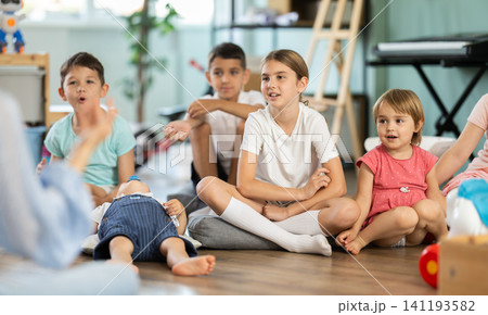 Children sit together and listen to the teacher 141193582