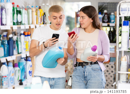 Young couple scanning QR-code on detergent in department store 141193785
