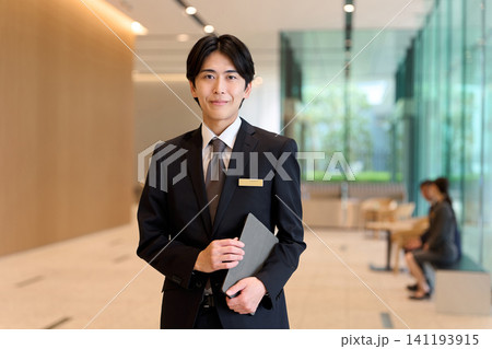 エントランスで案内するホテルスタッフ 141193915