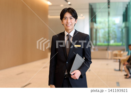 エントランスで案内するホテルスタッフ 141193921