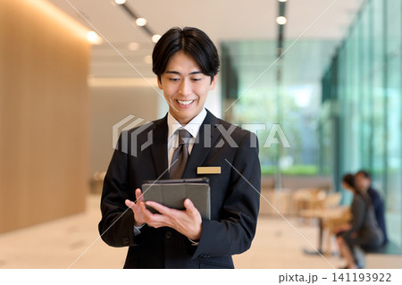 エントランスで案内するホテルスタッフ 141193922