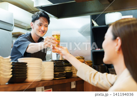 居酒屋でお客様にビールを提供する店長 居酒屋でお客様にビールを提供する店長 141194036