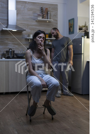 Terrified woman smokes after partner abuse at home, with bruises, sadness and alcoholism stress linking domestic violence to emotional distress. Terrified woman smokes after partner abuse at home, with bruises, sadness and alcoholism stress linking domestic violence to emotional distress. 141194536