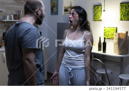 Husband and wife shout at each other during an aggressive domestic dispute, showing social problems, intimidation and violence inside a conflicted home. Husband and wife shout at each other during an aggressive domestic dispute, showing social problems, intimidation and violence inside a conflicted home. 141194577