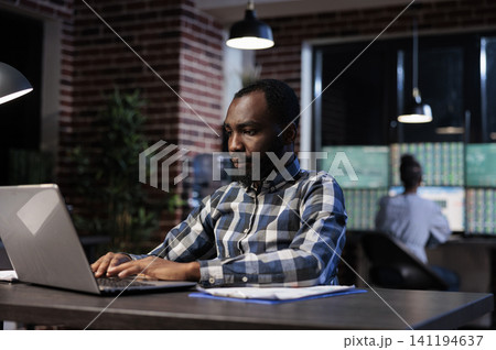 Professional trader uses a laptop at night to analyze market trends, technical charts and forex stock trading data in an office, for professional business and technology content. Professional trader uses a laptop at night to analyze market trends, technical charts and forex stock trading data in an office, for professional business and technology content. 141194637