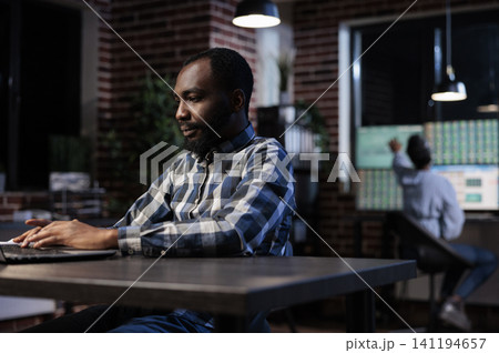 Investment employee reviewing portfolio documents highlighting and reviewing investors documentation and portfolio, Financial advisor analyzing forex stock market trend while sitting at desk. 141194657