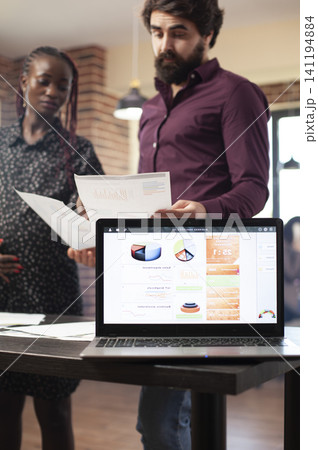 Financial laptop charts support market planning while reviewing laptop data, charts and documents for project planning, financial analysis and office presentation work. 141194884