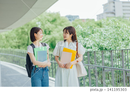 大学のキャンパスを歩く女子大生二人組 大学のキャンパスを歩く女子大生二人組 141195303