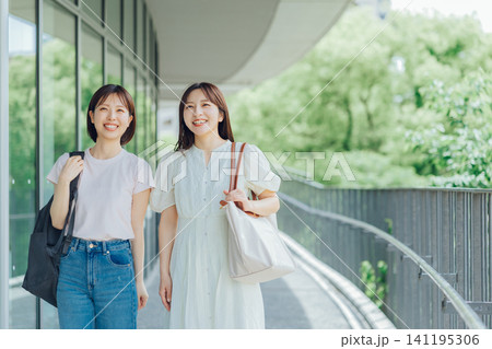 大学のキャンパスを歩く女子大生二人組 大学のキャンパスを歩く女子大生二人組 141195306
