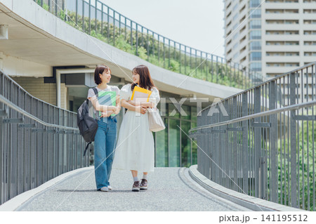大学のキャンパスを歩く女子大生二人組 大学のキャンパスを歩く女子大生二人組 141195512
