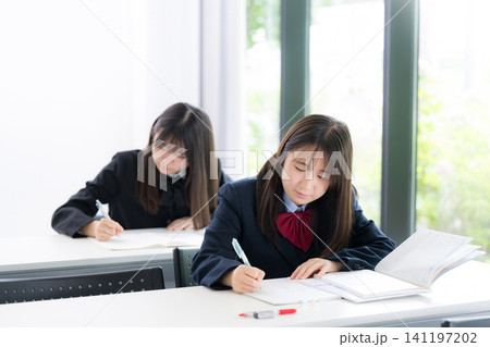 教室や塾で真剣に勉強へ取り組む日本人女子高校生　高校受験、大学受験の勉強イメージ正面 141197202
