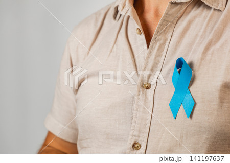 Support for health awareness shown through a blue ribbon on a man's shirt Support for health awareness shown through a blue ribbon on a man's shirt 141197637