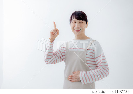 指差しをするエプロン姿の女性 指差しをするエプロン姿の女性 141197789