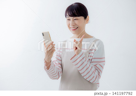 スマホを見る主婦 スマホを見る主婦 141197792