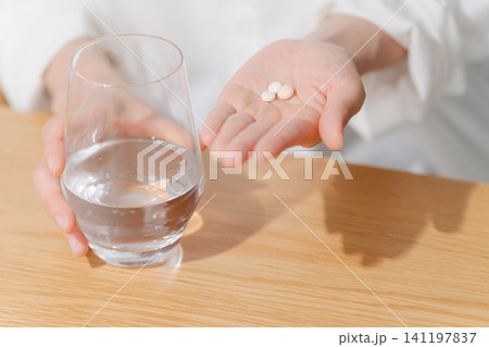 薬を飲む女性の手元 141197837