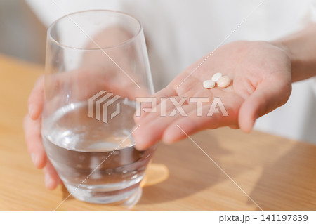 薬を飲む女性の手元 141197839