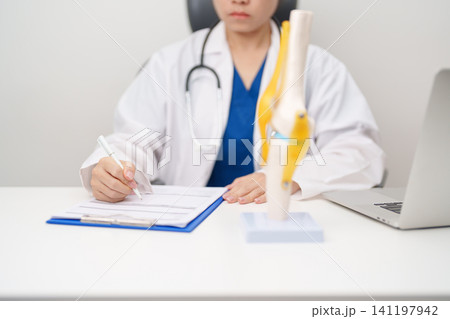 Doctor with Human Knee joint anatomy model. Osteoarthritis, Patellofemoral Pain Syndrome, Patellar Tendinitis, ACL, Anterior Cruciate Ligament, PCL, Posterior, MCL, Medial Collateral, LCL and Lateral 141197942