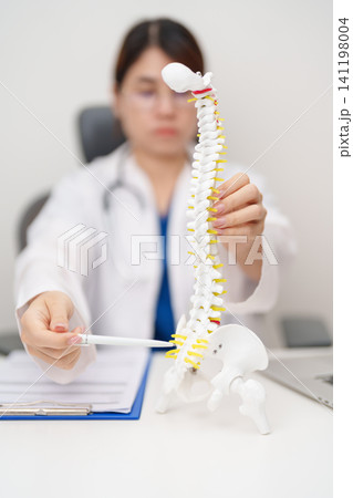 Doctor with human Spine anatomy model. Spinal Cord Disorder and disease, Back pain, Lumbar, Sacral pelvis, Cervical neck, Thoracic, Coccyx, Orthopedist, chiropractic, Office Syndrome and health Doctor with human Spine anatomy model. Spinal Cord Disorder and disease, Back pain, Lumbar, Sacral pelvis, Cervical neck, Thoracic, Coccyx, Orthopedist, chiropractic, Office Syndrome and health 141198004