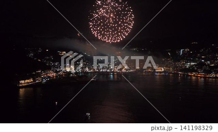 大きな赤い花火と海面に映る光の熱海夜景の空撮 大きな赤い花火と海面に映る光の熱海夜景の空撮 141198329